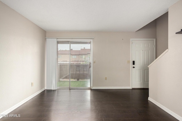 unfurnished room with baseboards and wood finished floors