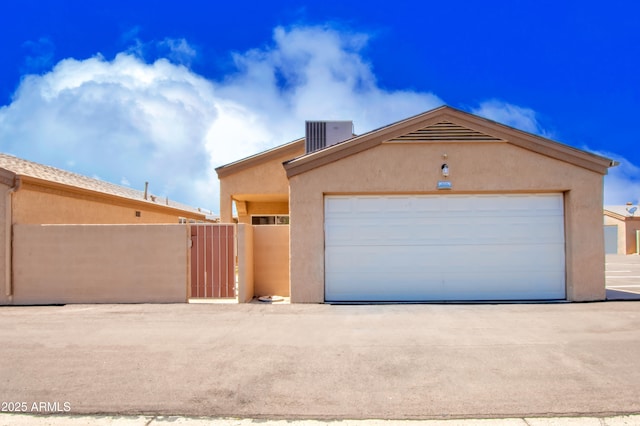 view of front facade featuring fence, a gate, central air condition unit, and stucco siding