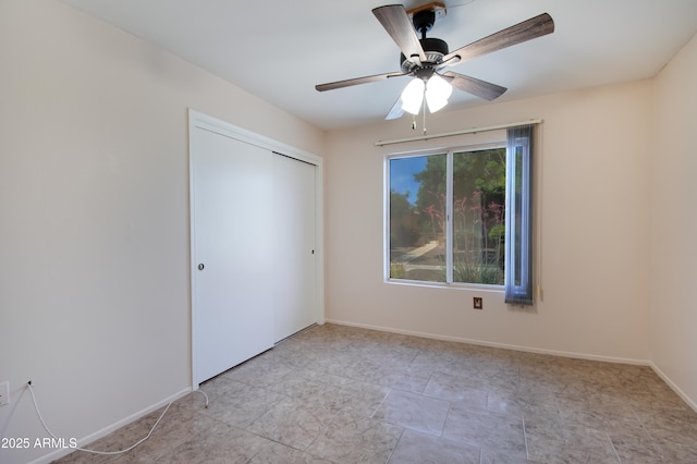 unfurnished bedroom featuring baseboards, ceiling fan, and a closet