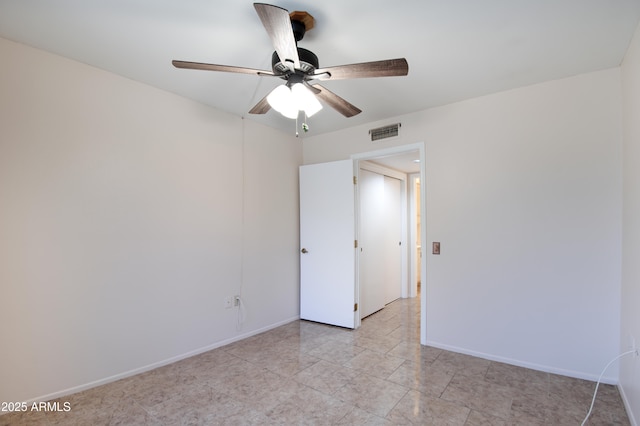 empty room featuring visible vents, a ceiling fan, and baseboards