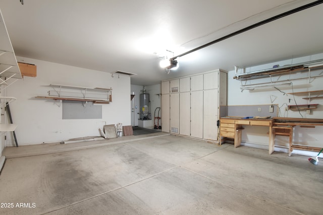 garage with a garage door opener, gas water heater, and a workshop area