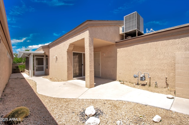 back of house featuring central air condition unit, stucco siding, and a patio area