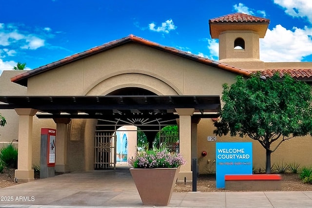 entrance to property featuring stucco siding and a tile roof
