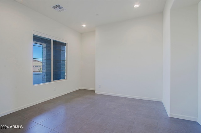 spare room featuring dark tile floors