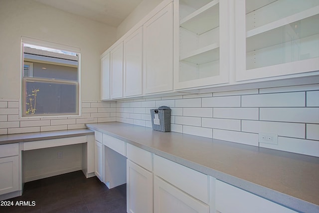 kitchen with white cabinets, backsplash, and dark tile floors