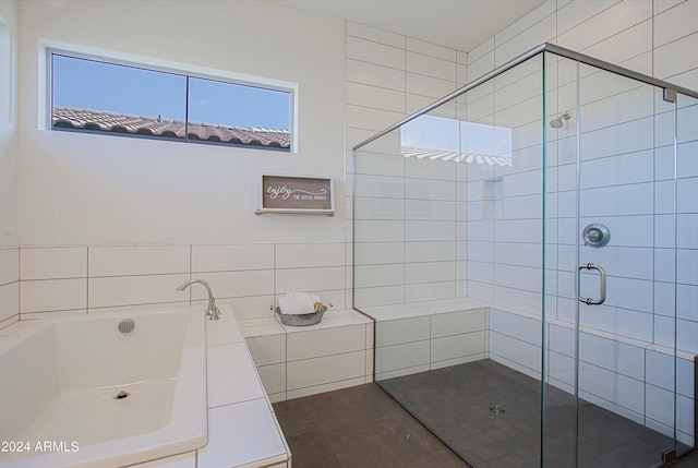 bathroom featuring tile flooring and separate shower and tub