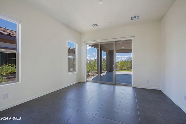 spare room featuring dark tile floors