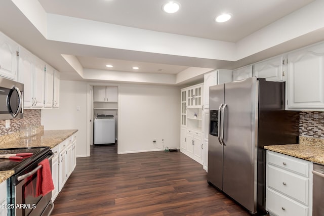 4802 W Hayward Ave, Glendale, AZ 85301 - kitchen featuring washer / dryer, appliances with stainless steel finishes, a tray ceiling, white cabinets, and dark wood finished floors