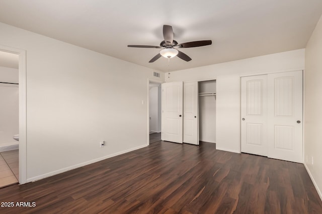 4802 W Hayward Ave, Glendale, AZ 85301 - unfurnished bedroom featuring dark wood-style flooring, two closets, baseboards, a ceiling fan, and connected bathroom