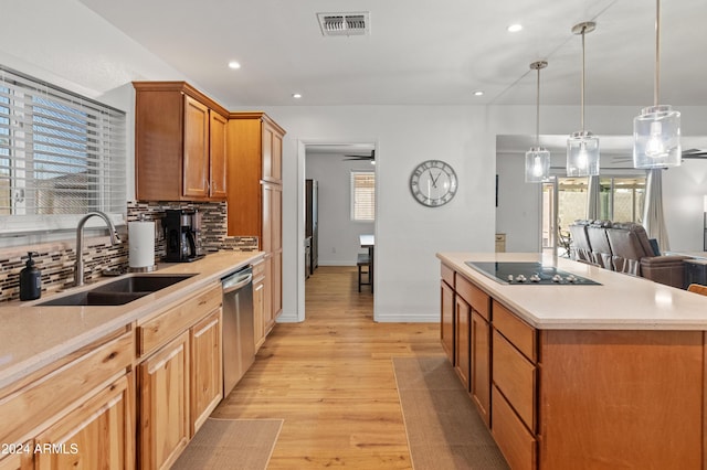 kitchen featuring sink, a center island, ceiling fan, stainless steel dishwasher, and backsplash