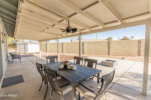 view of patio featuring a fire pit and a storage shed