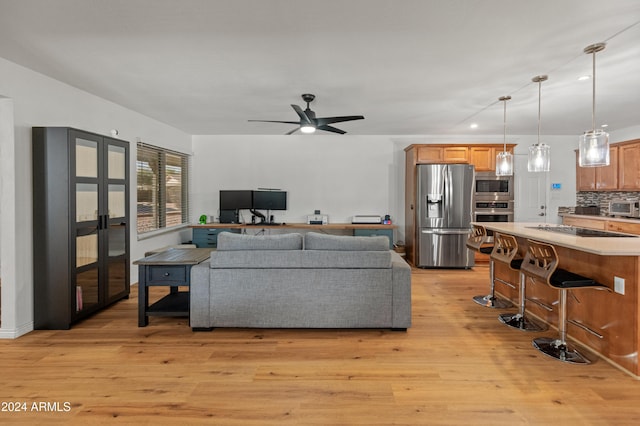 living room featuring ceiling fan and light hardwood / wood-style flooring