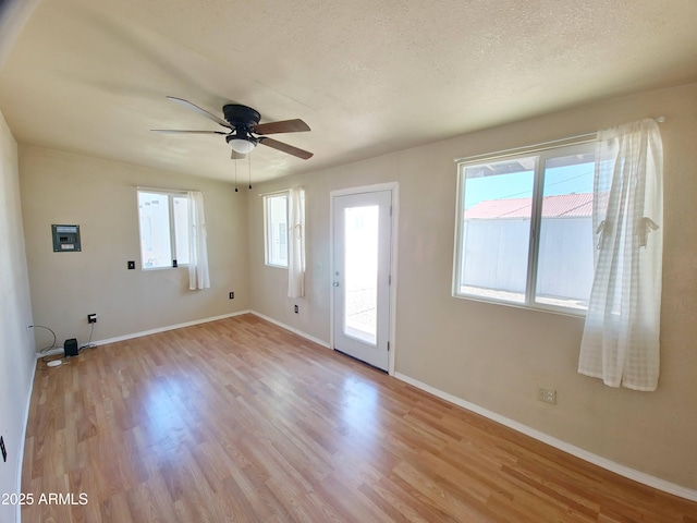 unfurnished room with plenty of natural light, light hardwood / wood-style flooring, and a textured ceiling