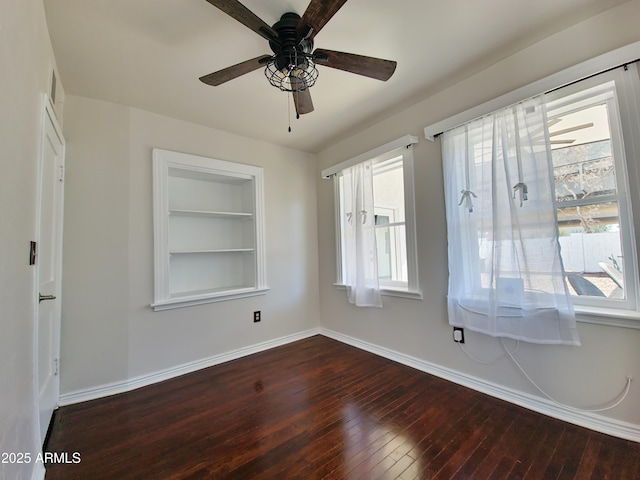 empty room with ceiling fan, hardwood / wood-style flooring, and built in shelves