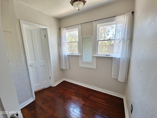 unfurnished room with dark hardwood / wood-style flooring