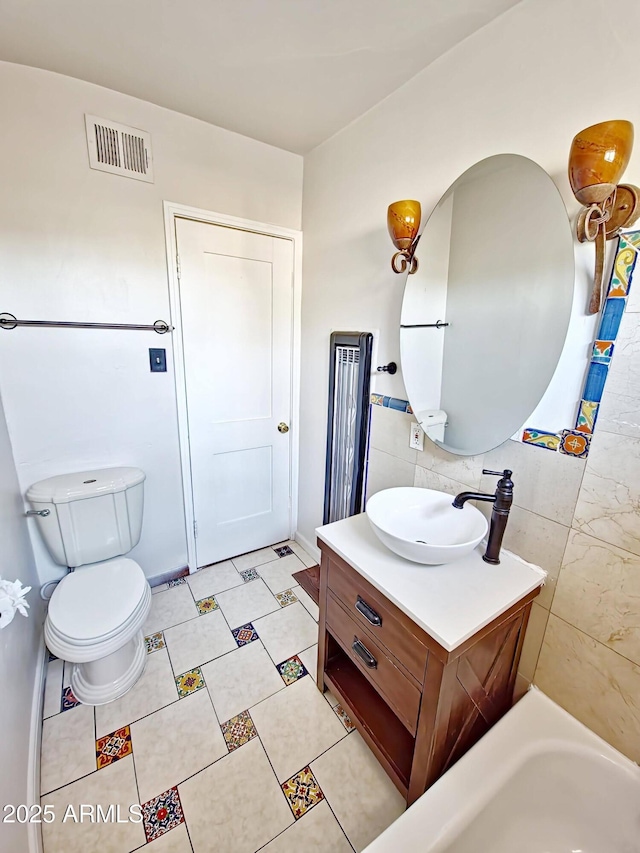 bathroom with vanity, backsplash, and toilet