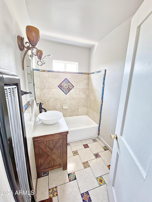 bathroom with tile patterned flooring, vanity, and tiled shower / bath