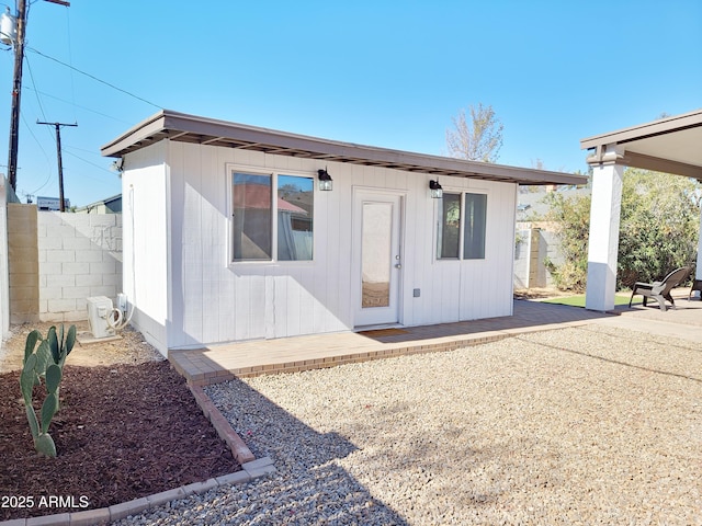 back of house with an outbuilding and a patio area