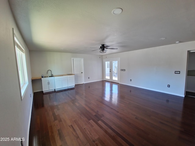 unfurnished living room featuring french doors, ceiling fan, dark hardwood / wood-style floors, and a textured ceiling