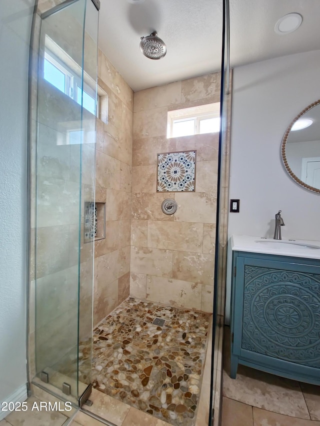 bathroom with a shower with door, sink, and tile patterned flooring