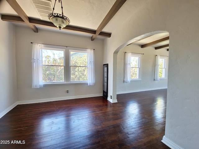 empty room with beamed ceiling and dark wood-type flooring