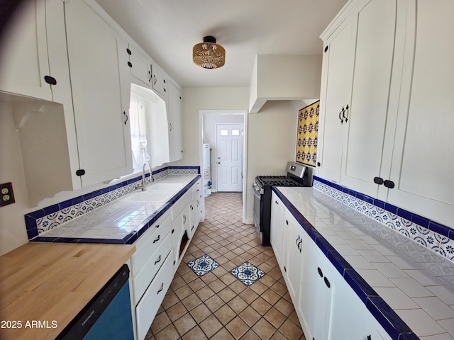 kitchen featuring white cabinetry, sink, tile countertops, and gas stove