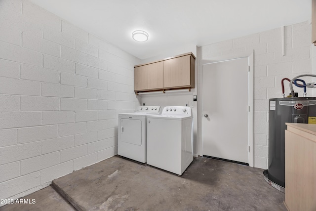 washroom featuring washer and clothes dryer, water heater, and cabinets