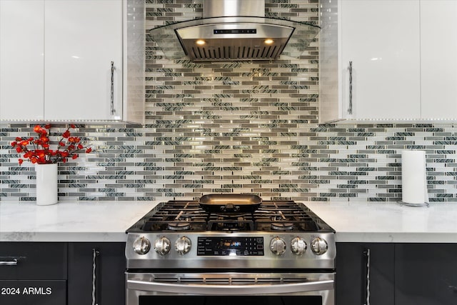 kitchen featuring tasteful backsplash, white cabinetry, light stone counters, and stainless steel gas range