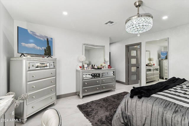 tiled bedroom featuring an inviting chandelier