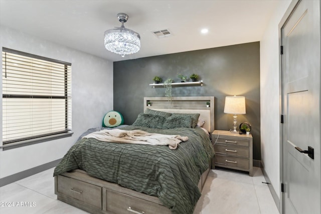 tiled bedroom featuring a chandelier