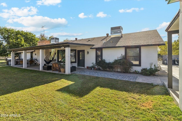 rear view of house with a lawn, a patio, and central AC