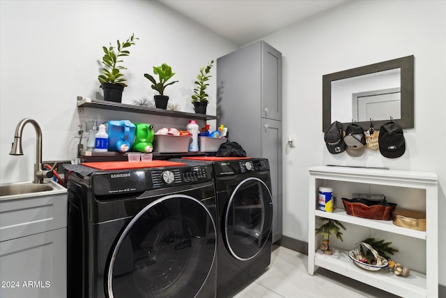 laundry room featuring cabinets, light tile patterned floors, washer and clothes dryer, and sink