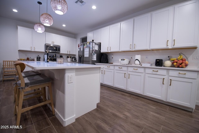 kitchen featuring stainless steel appliances, light countertops, white cabinets, and recessed lighting