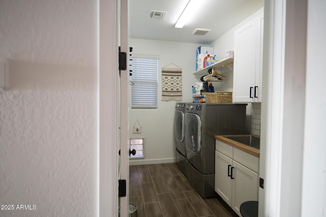 laundry area with washer and dryer, cabinet space, wood tiled floors, and baseboards