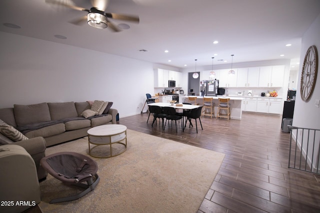 living area featuring dark wood-style flooring, recessed lighting, ceiling fan, and baseboards
