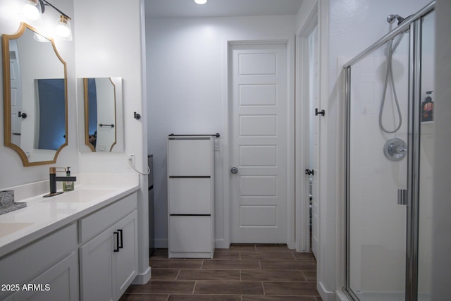 full bathroom featuring a stall shower, recessed lighting, double vanity, and wood tiled floors