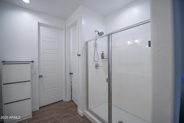 full bathroom with wood finish floors, a shower stall, and recessed lighting