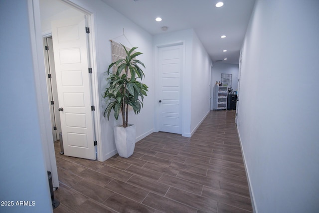 hallway featuring recessed lighting, baseboards, and dark wood-style floors