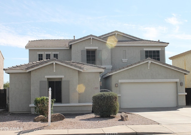 traditional-style house with driveway, a tiled roof, an attached garage, and stucco siding