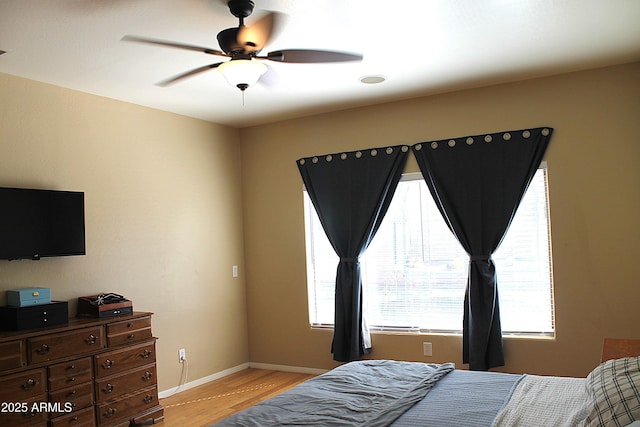 bedroom featuring light wood finished floors, ceiling fan, and baseboards