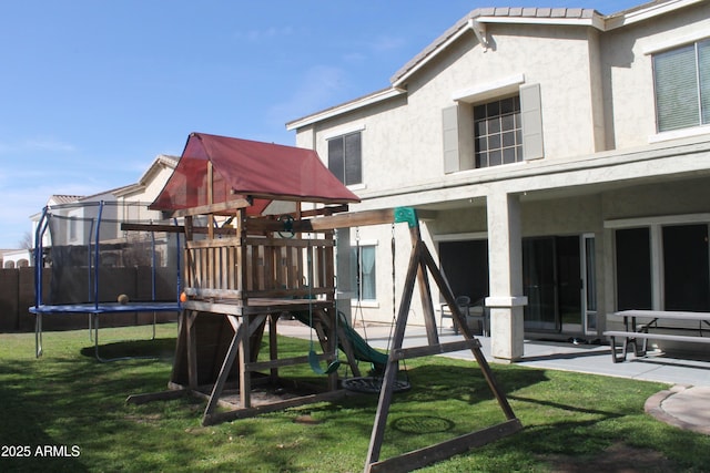 view of play area featuring a trampoline, a patio area, and a yard