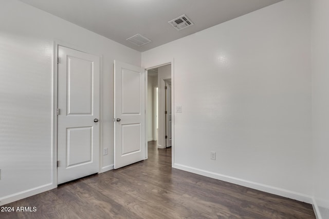 unfurnished bedroom with dark hardwood / wood-style flooring