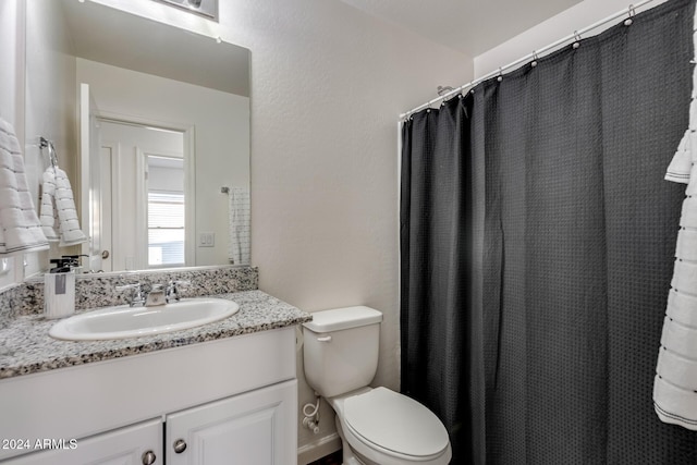 bathroom featuring vanity, toilet, and walk in shower