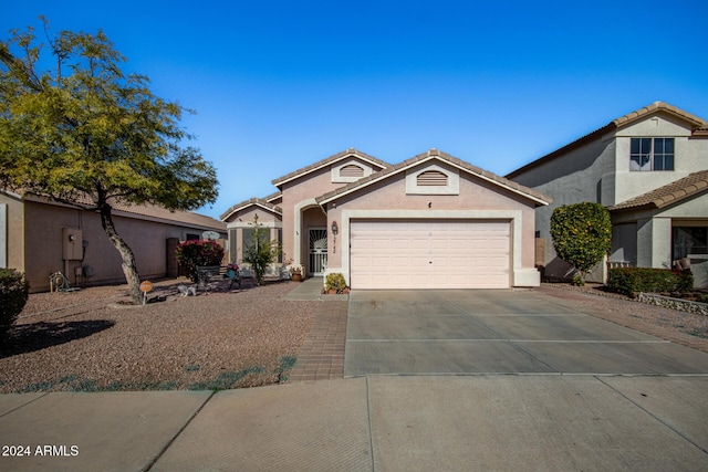 view of front of house with driveway, a tile roof, a garage, and stucco siding