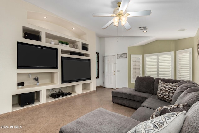 living room with built in features, a ceiling fan, vaulted ceiling, and light tile patterned floors