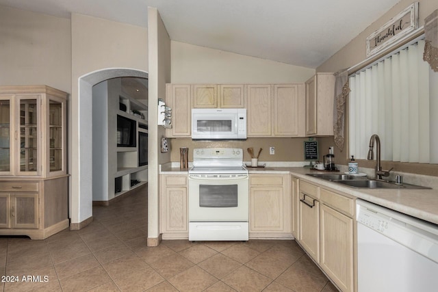 kitchen with white appliances, light tile patterned floors, light countertops, and a sink