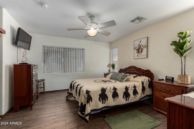 bedroom featuring visible vents, dark wood finished floors, baseboards, and ceiling fan