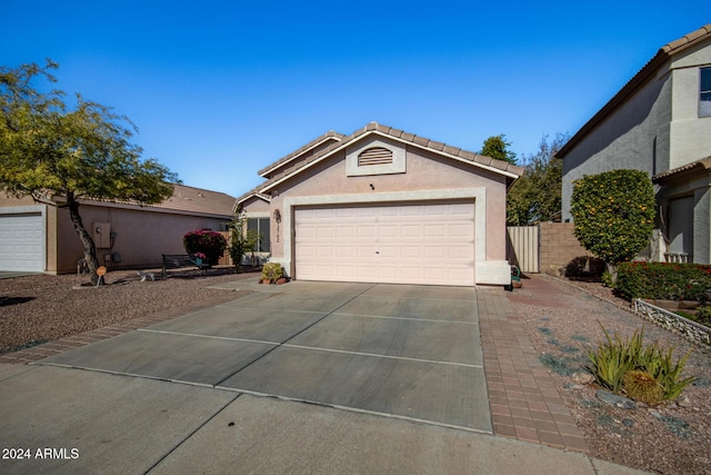 single story home featuring a tile roof, driveway, an attached garage, and stucco siding