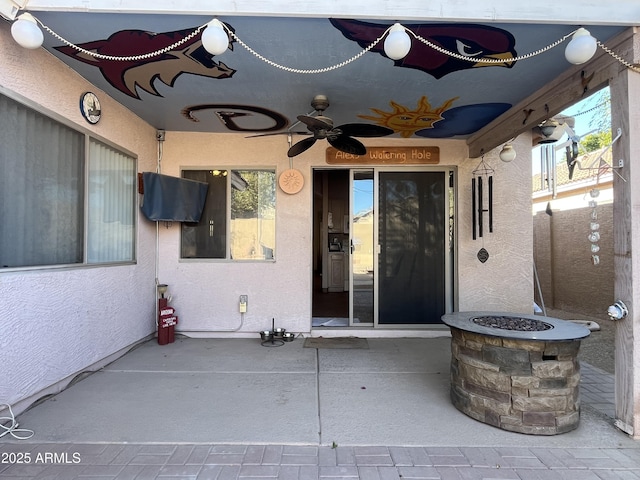 doorway to property featuring a patio area, a ceiling fan, and stucco siding