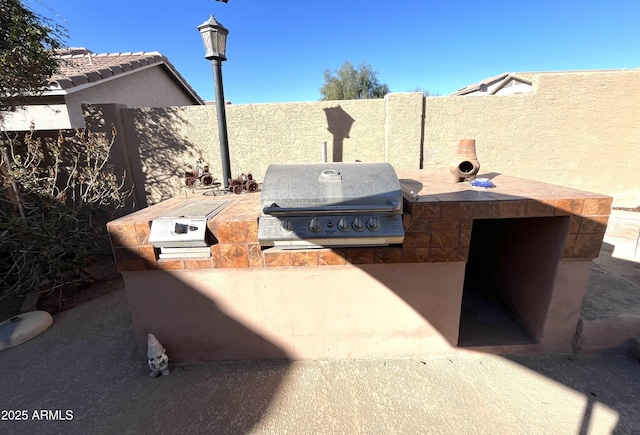 view of patio with a fenced backyard, area for grilling, and a grill